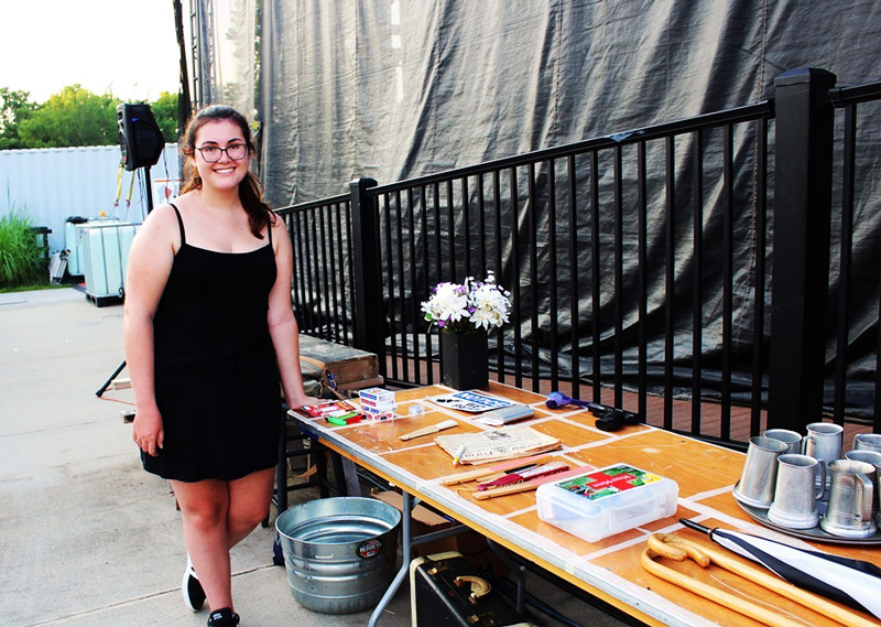 A volunteer helping with community theatre props at Leawood Stage Company's summer musical production of Kiss Me Kate near Kansas City